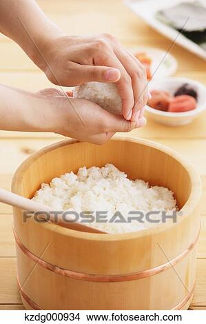 Picture - Young Japanese woman preparing Onigiri rice balls. Fotosearch
