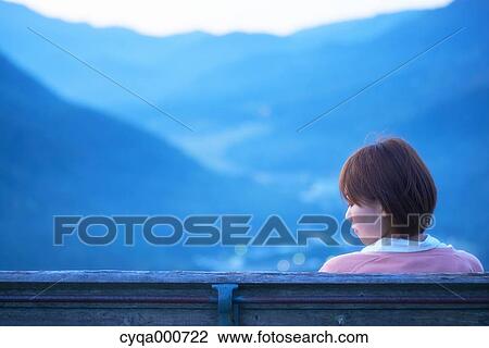 Young Japanese woman sitting on a bench in the countryside View Large Photo Image Stock Image - Young Japanese woman sitting on a bench in the countryside. Fotosearch