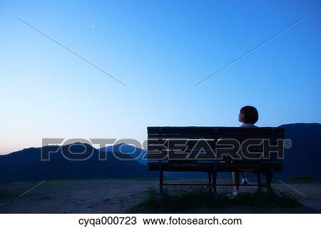 Young Japanese woman sitting on a bench in the countryside View Large Photo Image Stock Image - Young Japanese woman sitting on a bench in the countryside. Fotosearch