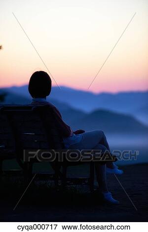Young Japanese woman sitting on a bench in the countryside View Large Photo Image Stock Photo - Young Japanese woman sitting on a bench in the countryside. Fotosearch
