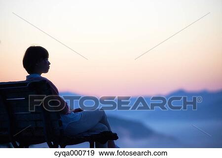 Young Japanese woman sitting on a bench in the countryside View Large Photo Image Stock Photo - Young Japanese woman sitting on a bench in the countryside. Fotosearch