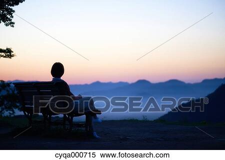 Young Japanese woman sitting on a bench in the countryside View Large Photo Image Stock Photography - Young Japanese woman sitting on a bench in the countryside. Fotosearch