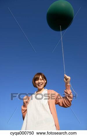 Young Japanese woman with green balloon in the countryside View Large Photo Image Stock Image - Young Japanese woman with green balloon in the countryside. Fotosearch