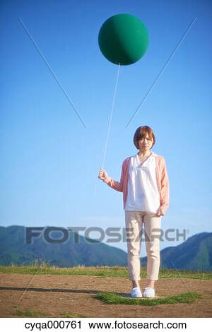 Young Japanese woman with green balloon in the countryside View Large Photo Image Stock Image - Young Japanese woman with green balloon in the countryside. Fotosearch