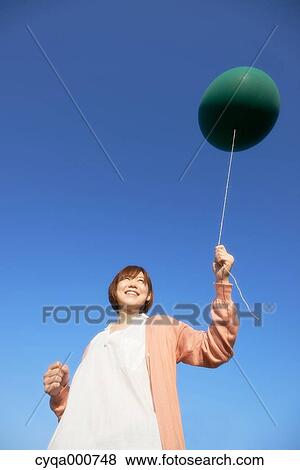 Young Japanese woman with green balloon in the countryside View Large Photo Image Stock Photo - Young Japanese woman with green balloon in the countryside. Fotosearch