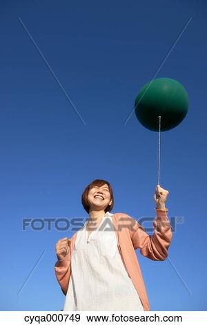 Young Japanese woman with green balloon in the countryside View Large Photo Image Stock Photo - Young Japanese woman with green balloon in the countryside. Fotosearch