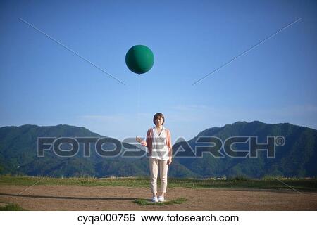 Young Japanese woman with green balloon in the countryside View Large Photo Image Stock Photograph - Young Japanese woman with green balloon in the countryside. Fotosearch