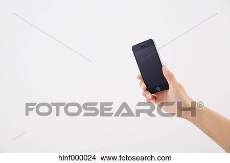 Picture - Young woman holding smartphone. Fotosearch