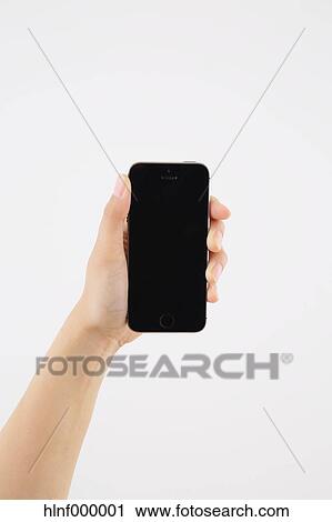 Stock Image - Young woman holding smartphone. Fotosearch