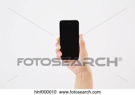 Stock Image - Young woman holding smartphone. Fotosearch