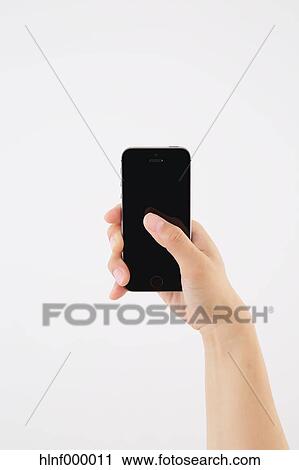 Stock Image - Young woman holding smartphone. Fotosearch