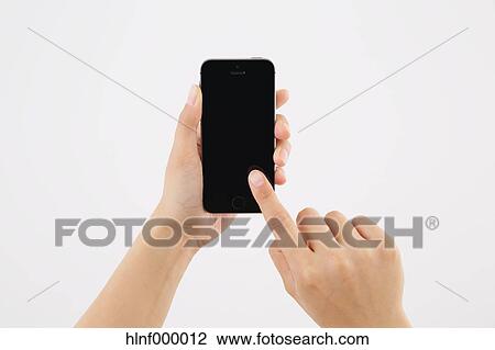 Stock Image - Young woman holding smartphone. Fotosearch