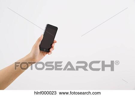 Stock Image - Young woman holding smartphone. Fotosearch
