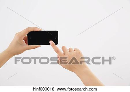 Stock Photo - Young woman holding smartphone. Fotosearch
