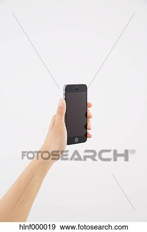 Stock Photo - Young woman holding smartphone. Fotosearch