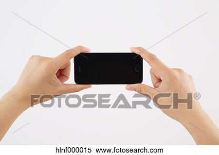 Stock Photography - Young woman holding smartphone. Fotosearch