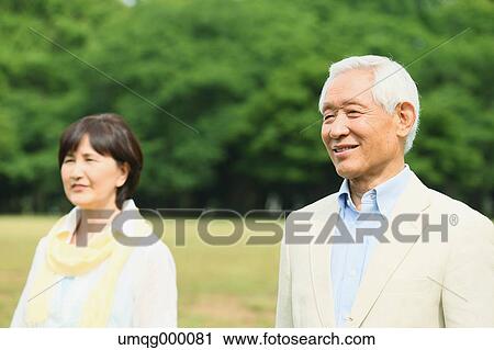 Stock Image - Senior adult Japanese couple in a park. Fotosearch