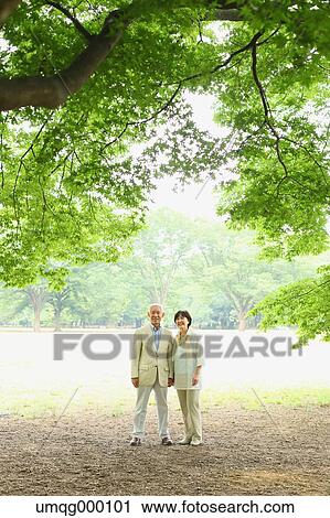 Stock Image - Senior adult Japanese couple in a park. Fotosearch