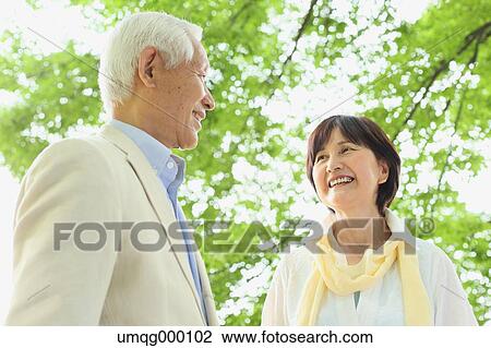 Stock Image - Senior adult Japanese couple in a park. Fotosearch
