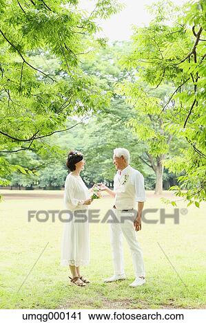 Stock Image - Senior adult Japanese couple in a park. Fotosearch