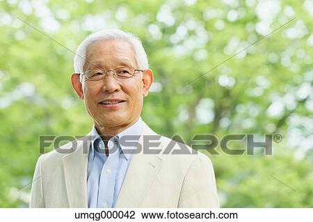 Stock Image - Senior adult Japanese man in a park. Fotosearch