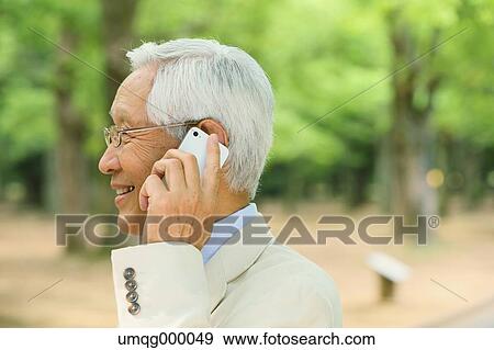 Senior adult Japanese man with smartphone in a park View Large Photo Image Stock Photo - Senior adult Japanese man with smartphone in a park. Fotosearch