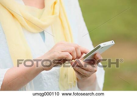 Senior adult Japanese woman with smartphone in a park View Large Photo Image Stock Image - Senior adult Japanese woman with smartphone in a park. Fotosearch