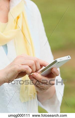 Senior adult Japanese woman with smartphone in a park View Large Photo Image Stock Image - Senior adult Japanese woman with smartphone in a park. Fotosearch