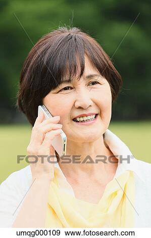Senior adult Japanese woman with smartphone in a park View Large Photo Image Stock Photo - Senior adult Japanese woman with smartphone in a park. Fotosearch