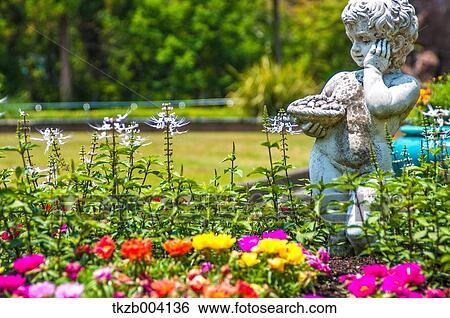 Stock Photograph - Statue in flower garden. Fotosearch