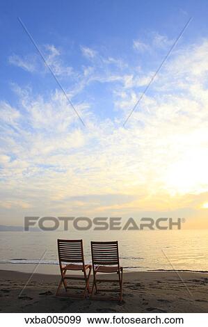 Stock Photo - Chairs At The Beach At Sunset. Fotosearch