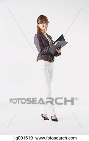 Stock Image - Full length portrait of Japanese young businesswoman against white background. Fotosearch