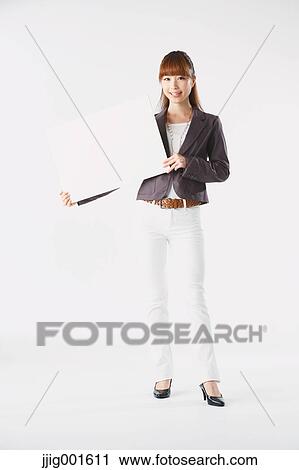 Stock Image - Full length portrait of Japanese young businesswoman against white background. Fotosearch
