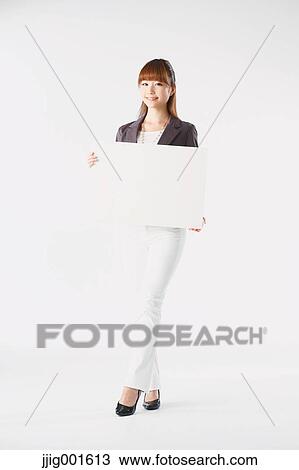 Stock Image - Full length portrait of Japanese young businesswoman against white background. Fotosearch