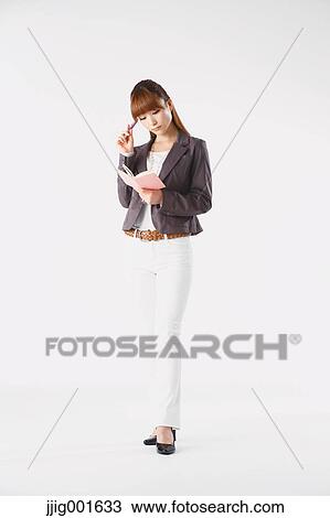 Stock Image - Full length portrait of Japanese young businesswoman against white background. Fotosearch