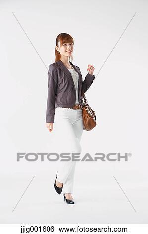 Stock Photograph - Full length portrait of Japanese young businesswoman against white background. Fotosearch