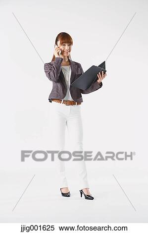 Stock Photography - Full length portrait of Japanese young businesswoman against white background. Fotosearch