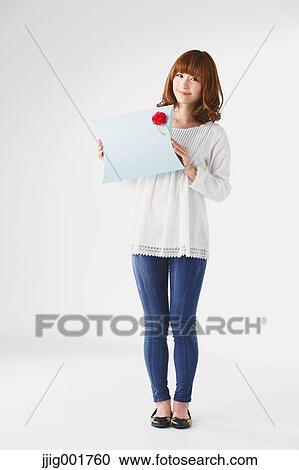Stock Image - Full length portrait of young Japanese woman against white background. Fotosearch
