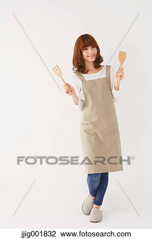 Stock Image - Full length portrait of young Japanese woman against white background. Fotosearch
