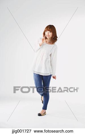 Stock Photo - Full length portrait of young Japanese woman against white background. Fotosearch