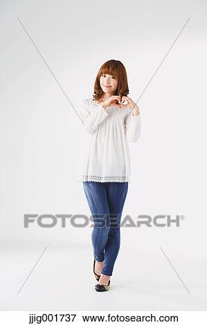 Stock Photo - Full length portrait of young Japanese woman against white background. Fotosearch