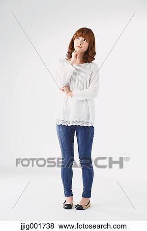 Stock Photo - Full length portrait of young Japanese woman against white background. Fotosearch