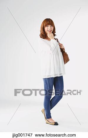 Stock Photo - Full length portrait of young Japanese woman against white background. Fotosearch