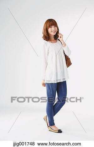 Stock Photo - Full length portrait of young Japanese woman against white background. Fotosearch