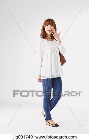 Stock Photo - Full length portrait of young Japanese woman against white background. Fotosearch