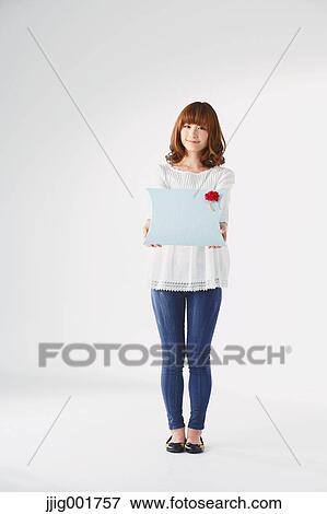 Stock Photo - Full length portrait of young Japanese woman against white background. Fotosearch