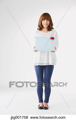 Stock Photo - Full length portrait of young Japanese woman against white background. Fotosearch