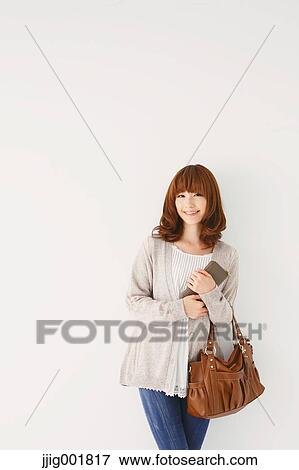 Stock Photo - Full length portrait of young Japanese woman against white background. Fotosearch