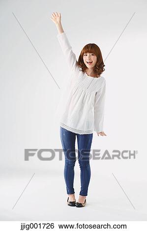 Stock Photograph - Full length portrait of young Japanese woman against white background. Fotosearch