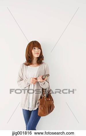 Stock Photograph - Full length portrait of young Japanese woman against white background. Fotosearch